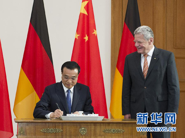 10月10日，國務(wù)院總理李克強在柏林會見德國總統(tǒng)高克。這是李克強總理在高克總統(tǒng)的陪同下在貴賓簿上簽字。 新華社記者 王曄 攝 